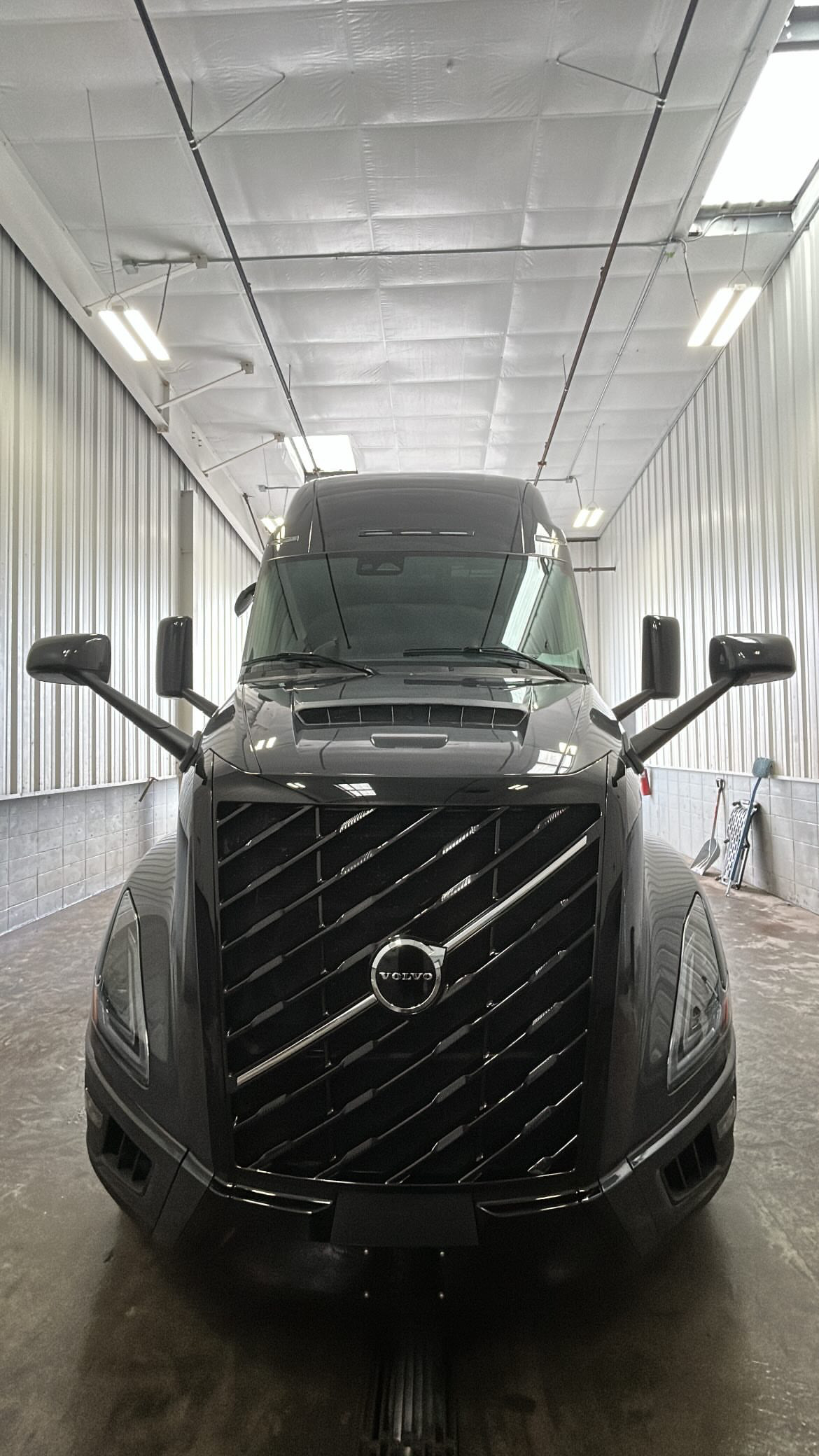 Black Volvo sleeper truck finished in a wash bay