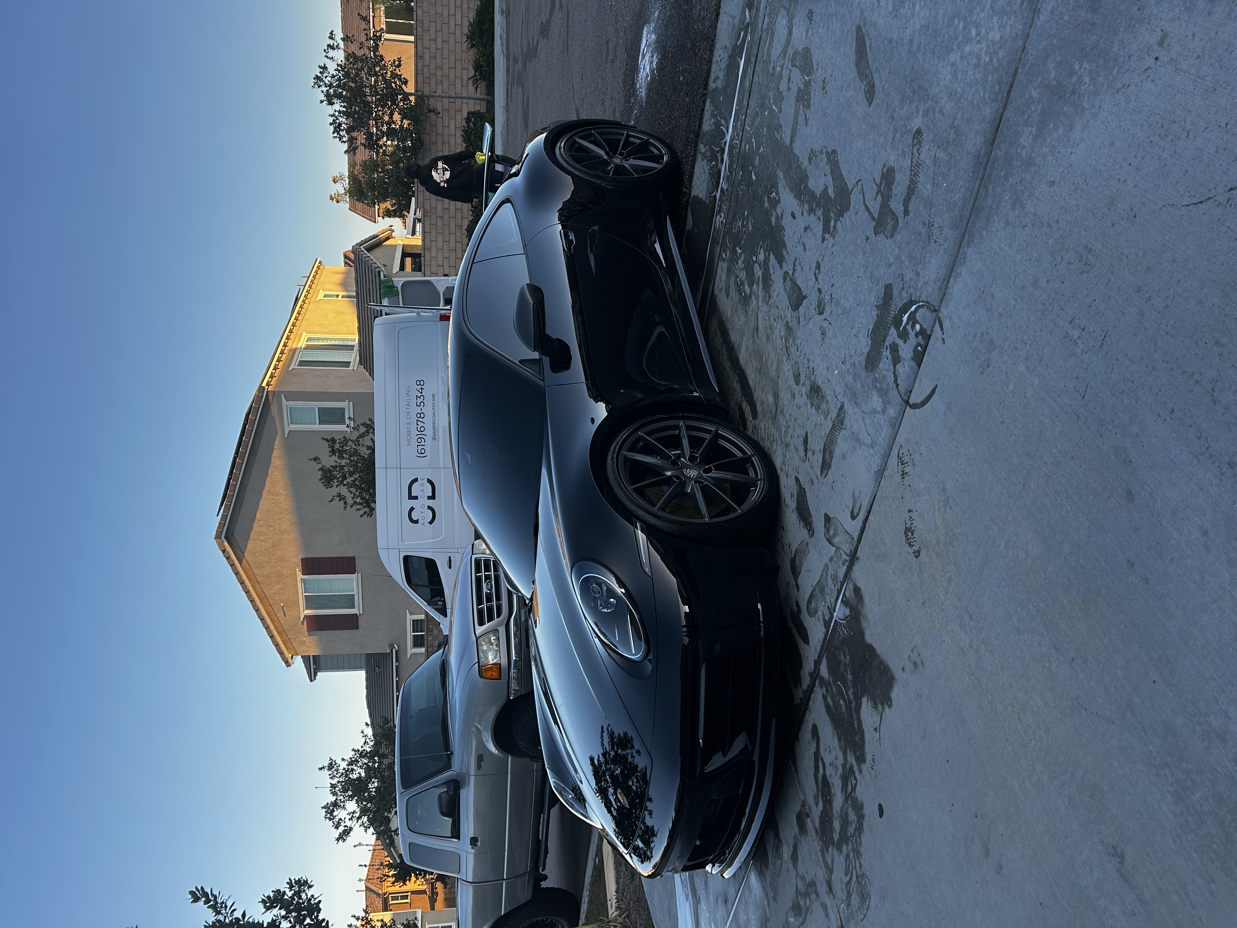 The same dark sports car rinsed and dried after the wash